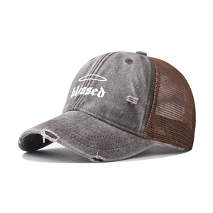 Detail of distressed grey cotton baseball cap with white 'blessed' embroidery and mesh back