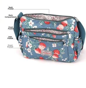 Detailed view of large capacity blue shoulder bag with strawberry print and multiple pockets