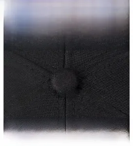Dettaglio macro del bottone superiore e cuciture rinforzate di un cappello di cotone nero