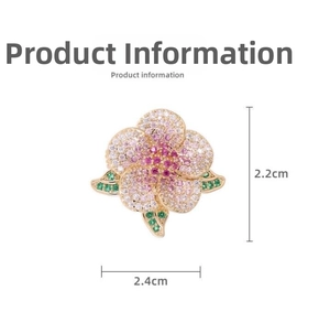 Macro detail of camellia brooch with pink zircons and gold base measuring 2.4cm