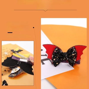 Detail of red bat wing hair clip with black sequin bow and metal alligator clip