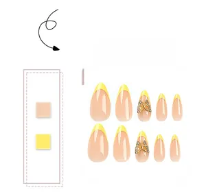 Detail of yellow French tip almond press-on nails with 3D gold butterfly rhinestones