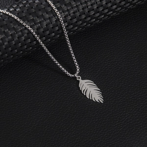 Collier punk vintage en acier inoxydable avec pendentif plume sur fond texturé noir