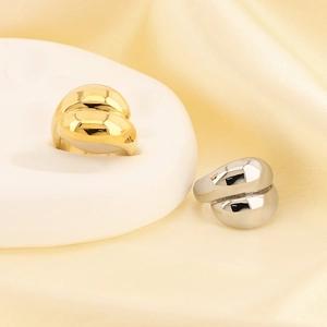 Minimalist gold and silver croissant rings with mirror polish on a white stone base