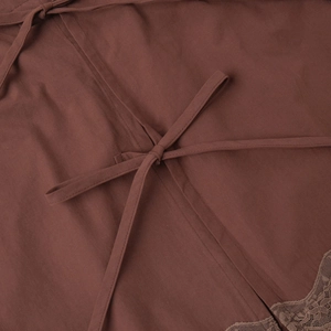 Detail of dark brown linen fabric with lace trim and adjustable lace-up tie closure