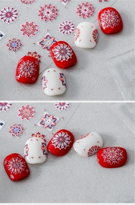 Detail of red and white mandala nail stickers with glitter accents for manicure designs