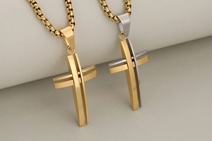 Detail of hollow 3D stainless steel cross pendants in gold and two-tone silver finishes