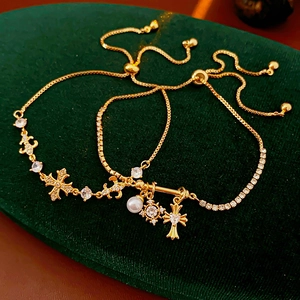 Détails des bracelets croix dorés avec perles et zircons sur velours vert foncé