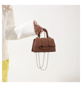 Close-up of brown litchi pattern mini handbag with silver bead chain and curved handle