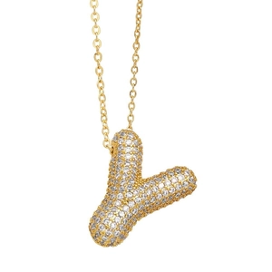 Close-up of golden balloon Y-letter pendant necklace with shimmering pave crystals