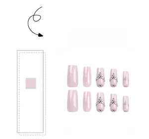 Detail of pink glitter press-on nails with rhinestone accents in long coffin shape