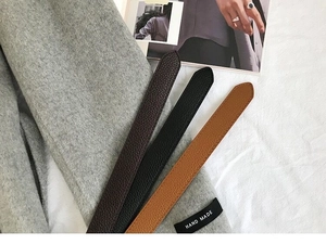 Drei Ledergürtel in Braun und Schwarz auf einem Wollmantel für herbstliches Styling