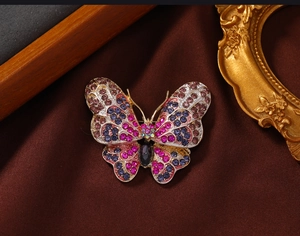 Detailed close-up of butterfly brooch with colorful rhinestones on vintage velvet background