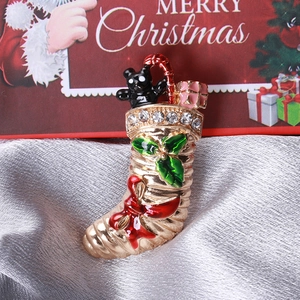 Détail d'une broche de Noël avec strass et émail sur un fond de tissu en soie