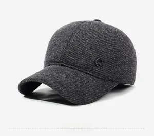 Detail view of dark grey wool blend texture and metal FS logo on winter baseball cap