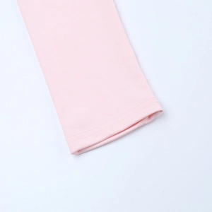 Détail du poignet d'une robe rose clair montrant les coutures doubles et le tissu doux