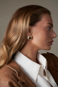 Elegante 18k vergoldete quadratische Ohrringe mit schwarzem Achat an einem Model
