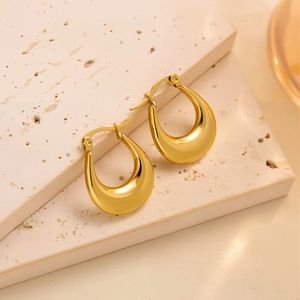 Gros plan de boucles d'oreilles goutte en or 18 carats sur base en pierre naturelle