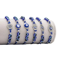 Detail view of Evil Eye beaded bracelets with Hamsa Hand charms on a jewelry display stand