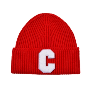 Detailed view of red ribbed knit beanie with white embroidered letter C patch detail