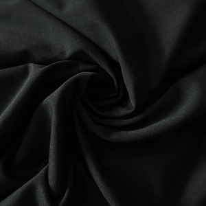 Detailed close-up of black textured fabric with spiral pleats and elastic material