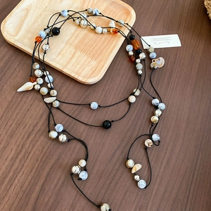 Detail of bohemian layered beads necklace with shells and colorful marble textures