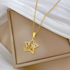 Detail of gold star pendant with Mama engraving and diamonds on beige box