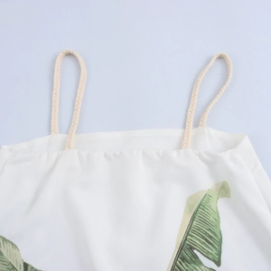 Relaxed white A-line dress with green tropical leaf print and woven rope straps