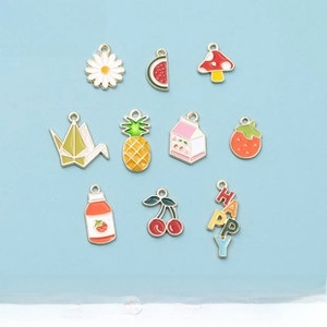 Detail of colorful alloy enamel charms including daisy, fruits, and mushrooms for DIY jewelry