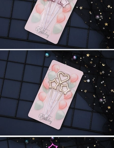 Close-up of gold heart and star candles on a decorative party-themed card packaging