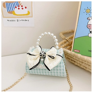 Close-up of mint green houndstooth girl's bag with lace bow and pearl handle detail
