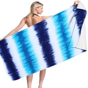 Detail of blue and white tie-dye microfiber beach towel held by a model on white background