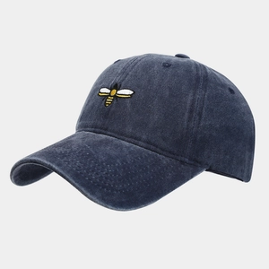 Close-up of small bee embroidery on vintage washed navy blue cotton baseball cap
