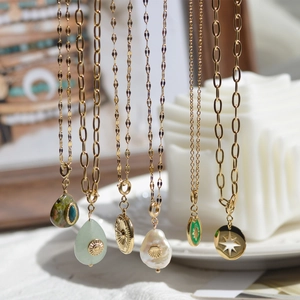 Detail of vintage gold stainless steel necklaces with natural stones and baroque pearls