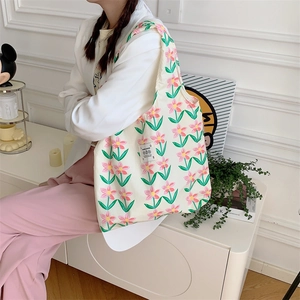 Dettaglio della borsa shopper in tela con motivi floreali rosa su tessuto crema