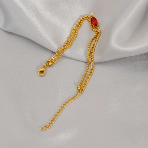 Double-layer gold titanium steel bracelet with red marquise zircon on satin background