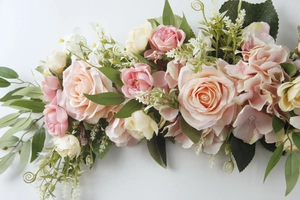 Close-up of pink and cream silk roses with green leaves for wedding chair decor