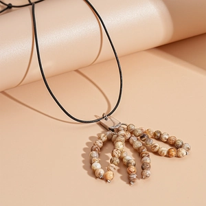 Close-up of vintage multi-strand brown stone beads fringe pendant on black cord necklace