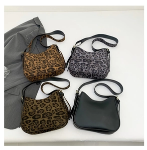 Flat lay of leopard print shoulder bags in brown, grey, and black on white background