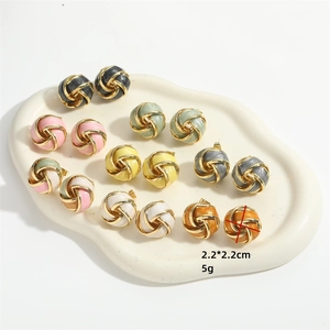 French vintage vortex knot earrings in colorful enamel set on a white ceramic tray