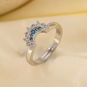 Vintage silver moon ring with micro-set blue and white zircons on a yellow silk backdrop