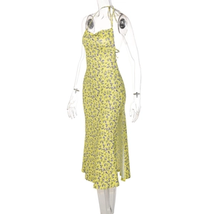 Detail view of yellow floral sundress featuring a side slit and purple flower patterns