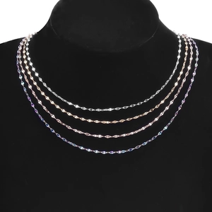 Detail of four colorful layered stainless steel necklaces shown on a black mannequin