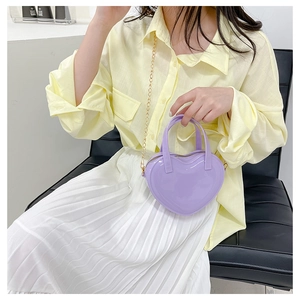 Fashionable purple heart-shaped jelly bag with gold chain strap shown on a model