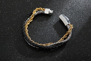 Detail view of men's triple-layer bracelet with black leather, gold rope, and steel chains