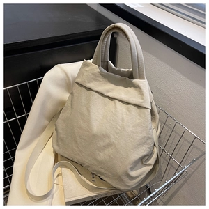 Detail view of off-white nylon tote bag with pleated texture in a silver shopping basket