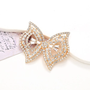 Sparkling gold crystal bowknot accessory with clear rhinestones on white background