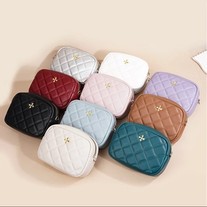 Flat lay of multiple color options for the quilted crossbody camera bags with gold accents