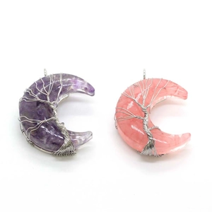 Detail of tree of life pendants in moon shape with purple and pink crystals