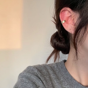 Minimalist S925 silver irregular golden ear cuff worn on model with soft lighting